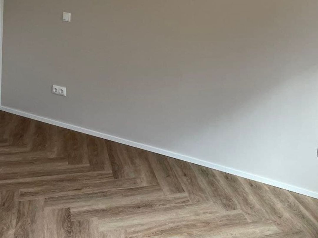 Sauber zugeschnittener Bodenanschluss an Wand und Sockelbereich